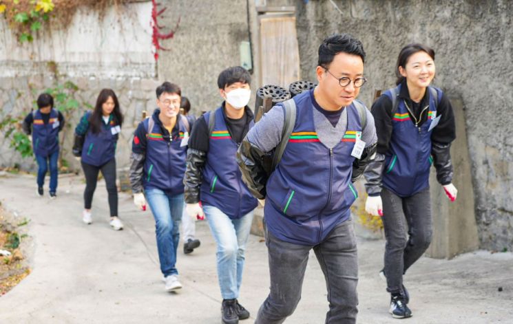 이정윤 세븐일레븐 경영지원부문장(왼쪽 다섯번째)과 경영주, 임직원이 서울 노원구 '백사마을' 주민을 위한 '사랑의 연탄 나눔 봉사'를 진행하고 있다(사진제공=세븐일레븐).