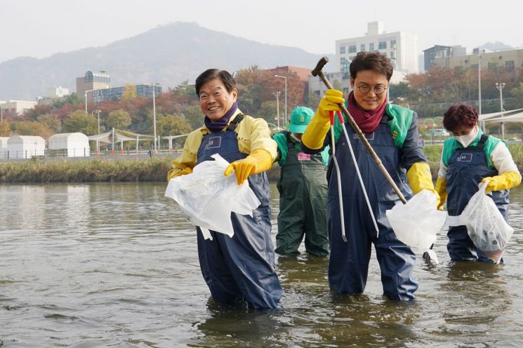 이필형 동대문구청장(사진 왼쪽)이 9일 오전 새마을운동 동대문구지회 회원들과 중랑천에서 쓰레기를 수거하고 있다.