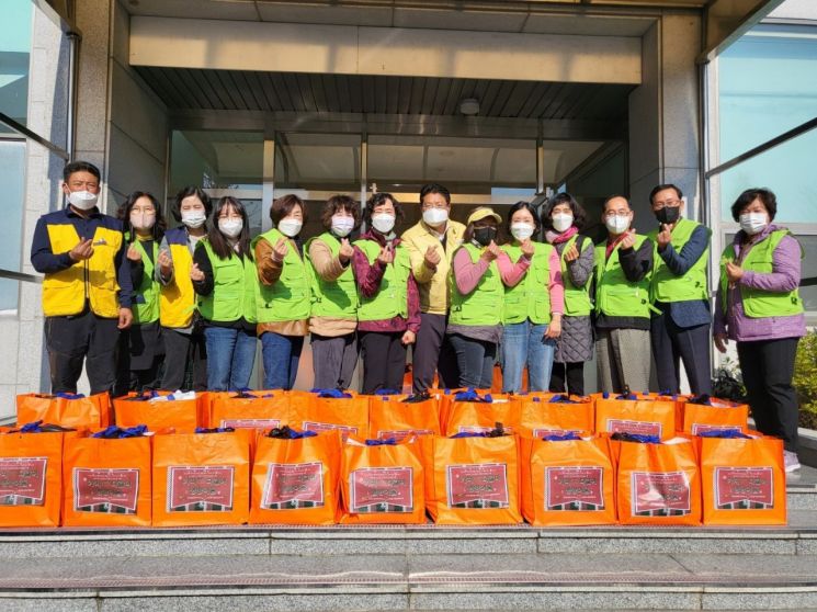김종천 정관읍장(오른쪽에서 7번째)과 봉사자들이 취약계층에게 건강식품꾸러미를 전달하고 있다.