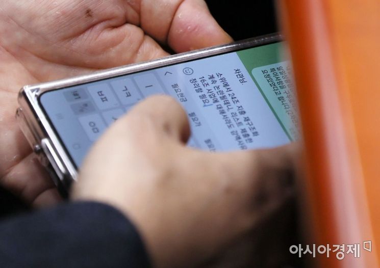 17일 국회에서 열린 예산결산소위에 참석한 한 차관이 예산안 관련 보고를 SNS를 통해 받고 있다./윤동주 기자 doso7@