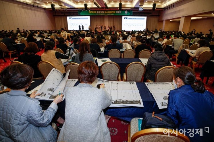 18일 서울 광진구 세종대학교 컨벤션홀에서 열린 '종로학원, 2023 정시 대입설명회'에 참가한 학부모들이 정시 배치 참고표를 보고 있다./강진형 기자aymsdream@