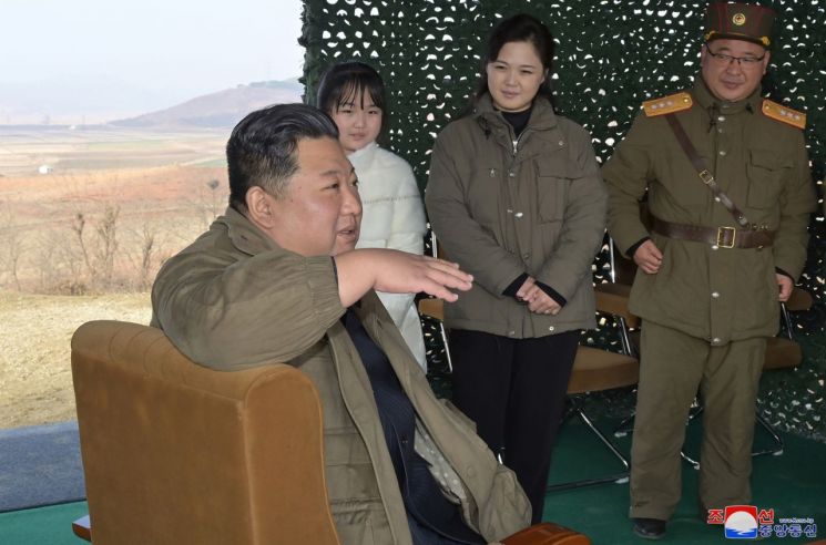 북한이 김정은 국무위원장 자녀를 처음으로 공식 공개했다. 자리에 앉아 군부 인사들에게 손짓하며 지시하는 김 위원장의 말을 리설주 여사와 딸이 나란히 서서 손을 모은 채 듣고 있다. 사진=연합뉴스