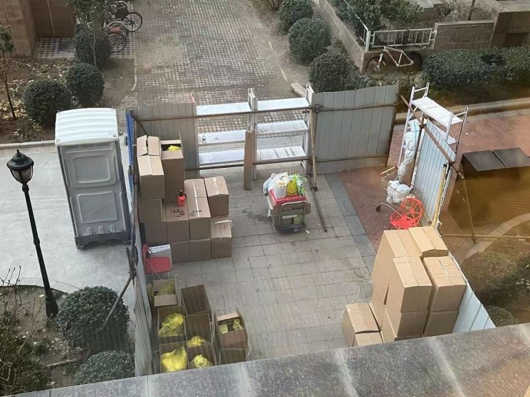 이달 16일, 집에 들어오자마자 봉쇄 작업이 시작됐다. 현관은 두꺼운 잠금쇠로 잠겼고, 빠르게 조달된 쇠파이프와 철판이 주변인의 출입을 막았다. 좌측엔 관리원들을 위한 간이 화장실이 설치됐고, 노란 봉투안에 든 각 가구의 폐기물은 상자에 담겨 실려나갔다. (사진=김현정 특파원)