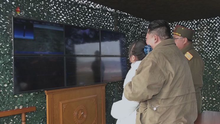 북한이 지난 18일 김정은 노동당 총비서의 지도 아래 신형의 대륙간탄도미사일 화성-17형을 시험 발사했다고 조선중앙TV가 20일 보도했다. 사진은 조선중앙TV가 이날 추가로 공개한 총비서가 딸을 품에 안은 채 모니터를 바라보는 모습. 모니터에 띄워진 화면은 확인할 수 없게 처리되어 있다. [이미지출처=연합뉴스]