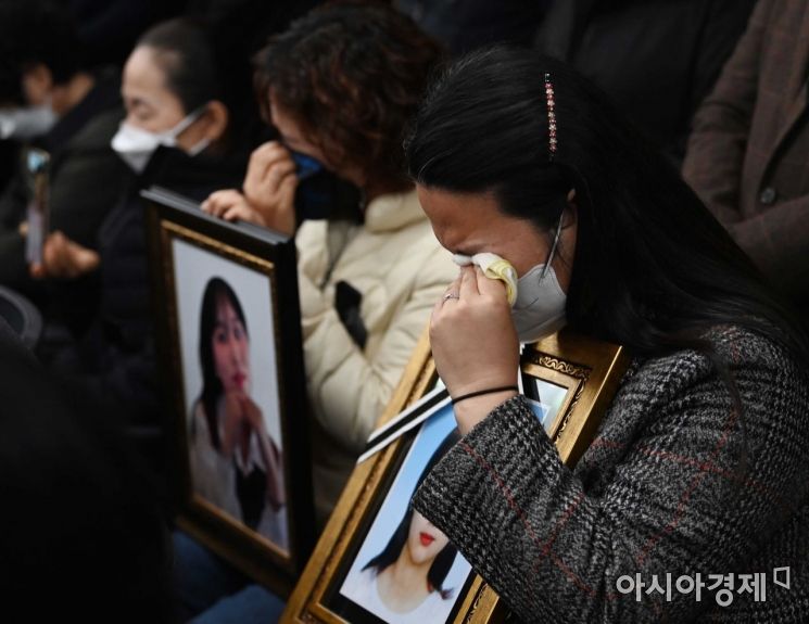 이태원 참사 유가족들이 22일 오전 서울 서초구 민주사회를 위한 변호사모임(민변) 대회의실에서 열린 입장발표 기자회견에서 자식의 영정사진을 품에 안고 눈물을 흘리고 있다./강진형 기자aymsdream@