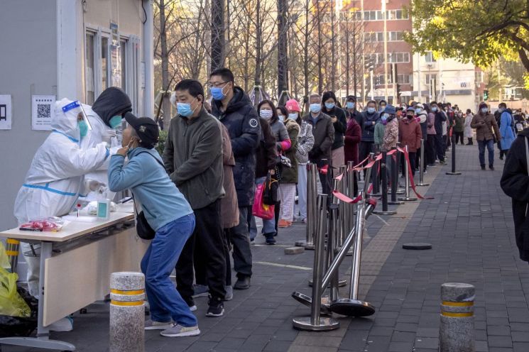15일 중국 베이징의 한 선별진료소에서 시민들이 코로나19 유전자증폭(PCR) 검사를 받기 위해 줄을 서 있다. 사진=연합뉴스