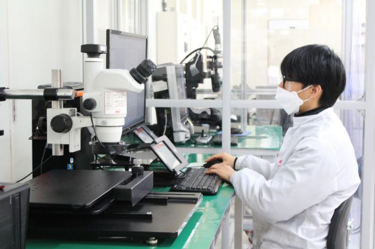 큐알티 연구원이 광학현미경을 활용해 반도체 제품 불량을 분석하고 있다.