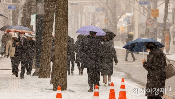 중부지방 곳곳에 대설주의보가 발령된 15일 서울 중구 서울시청에서 시민들이 내리는 눈을 맞으며 이동하고 있다./강진형 기자aymsdream@