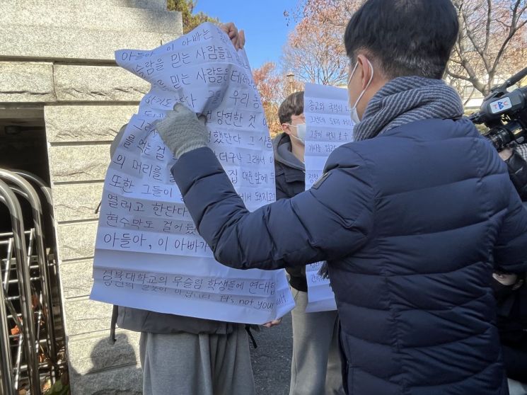 '대현동 이슬람사원 건립 반대 비대위'가 15일 대구 북구 경북대 서문에 경북대 재학생과 졸업생 2명이 비대위의 돼지고기 행사를 비판하는 대자보를 붙이려고 하자 항의하고 있다. [이미지출처=연합뉴스]