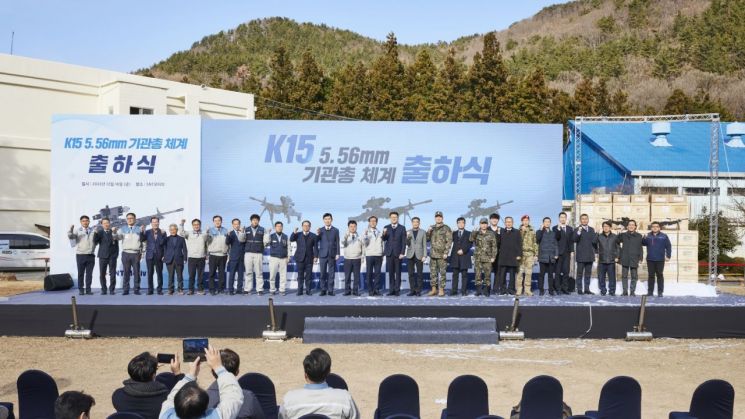 K15 기관총 체계 출하식에서 군과 참여 기업 관계자들이 기념 사진을 찍고 있다.