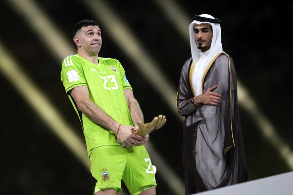 아르헨티나 골키퍼 에밀리아노 마르티네스(왼쪽)가 19일(한국시간) 2022 카타르 월드컵 우승 시상식에서 골든글러브를 수상한 뒤 세리머니를 펼치고 있다. 사진=AP·연합뉴스