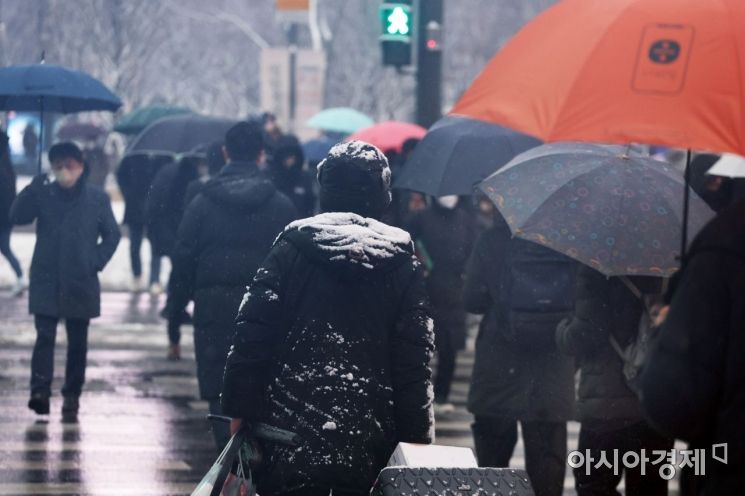 새벽부터 눈이 내린 21일 서울 광화문 네거리를 시민들이 걸어가고 있다. /허영한 기자 younghan@