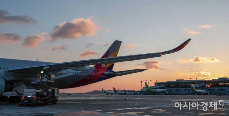 인천국제공항 제1여객터미널 활주로에서 아시아나항공 관계자가 운항을 앞둔 비행기에 주유를 하며 마지막 점검을 하고 있다./영종도=강진형 기자aymsdream@