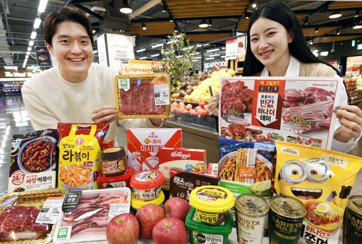 서울 홈플러스 메가푸드마켓 강서점에서 모델들이 ‘반값 하나 더 데이’ 행사상품을 소개하고 있다. (사진제공=홈플러스)