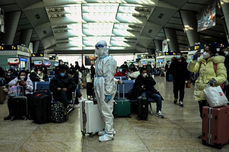 지난달 말 중국 베이징 기차역에 한 승객이 방역복을 갖춰 입고 서있다. [이미지출처=AFP연합뉴스]