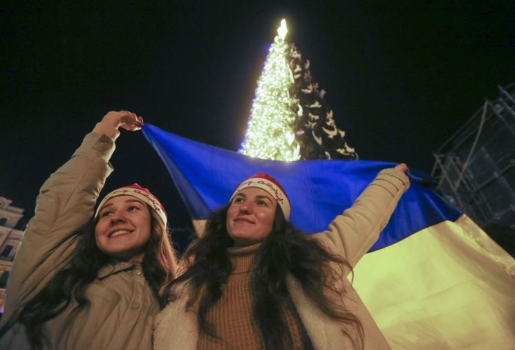 2022년의 마지막 날(31일·현지시간) 저녁 우크라이나 수도 키이우 시내에서 시민들이 국기를 들고 새해맞이를 준비하고 있다. ＜사진=EPA연합＞
