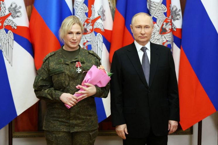 지난달 31일 블라디미르 푸틴 러시아 대통령이 안나 시도렌코라고 소개된 우크라이나 전쟁 의무병에게 훈장을 수여했다. [이미지출처=로이터연합뉴스]