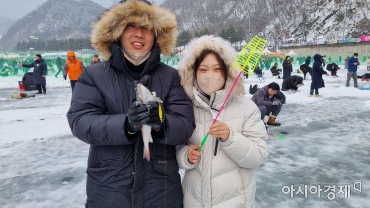 산천어를 낚은 관광객이 즐거워하고 있다. [라영철]