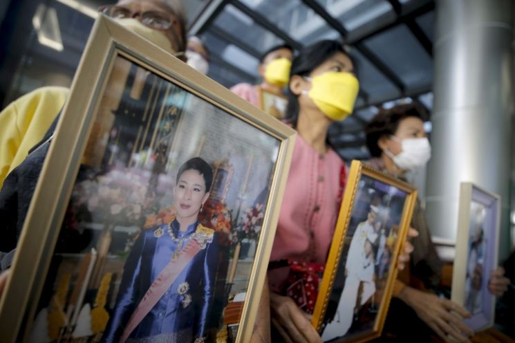 지난달 19일(현지시간) 태국 방콕 출라롱꼰기념병원 앞에서 태국인들이 팟차라끼띠야파 공주의 사진을 들고 그의 쾌유를 기원하고 있다. 사진=EPA 연합뉴스