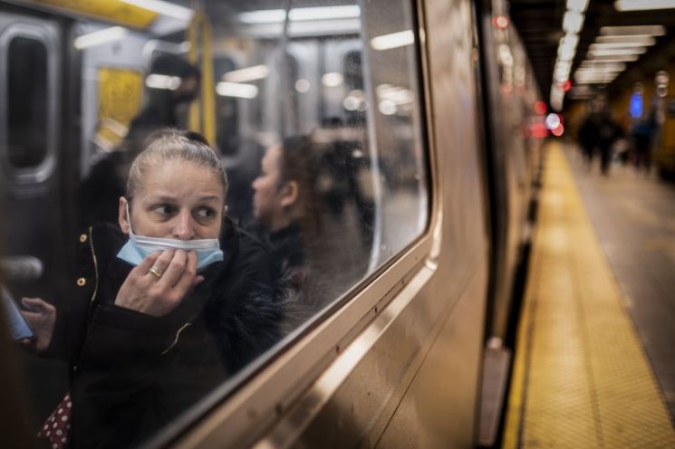 뉴욕의 지하철에서 한 승객이 마스크를 쓴 채 바깥을 내다보고 있다. [이미지출처=AP연합뉴스]