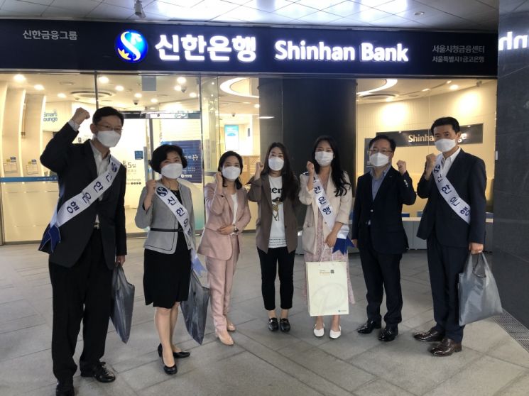 신한은행 서울시청센터 직원들이 지난해 초 캠페인을 벌인 후 센터 앞에서 기념촬영을 하고 있다.