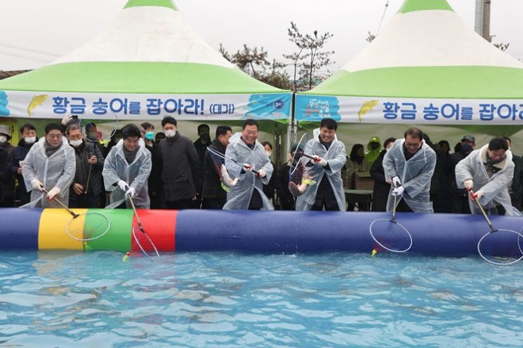 (좌측 세번째)김산 무안군수와 (좌측 두번째)김경현 의장이 축제 시작을 알리는 숭어잡기 포퍼먼스를 하고 있다. [사진제공=무안군]