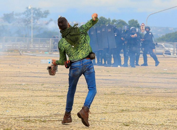 자이르 보우소나루 브라질 전 대통령 지지자가 8일(현지시간) 경찰에게 돌을 던지고 있다. [이미지출처=연합뉴스]