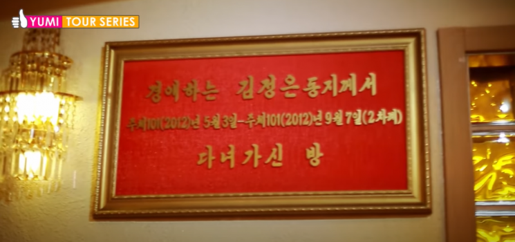 '통일거리운동센터' 헬스장 입구 옆에 있는 팻말. '경애하는 김정은 동지께서 다녀가신 방'이라고 적혀 있다./유튜브 캡처
