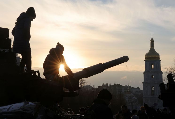 우크라이나 키이우 성 미하일 수도원 앞에서 아이들이 파괴된 러시아 탱크 위에 올라가 있다. [이미지출처=연합뉴스]