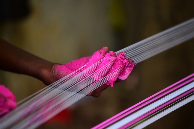 한 남성이 인도 구자라트주에서 열린 우타라얀 축제에 참여하기 위해 연줄에 색을 입히고 있다. [이미지 출처=AFP 연합뉴스]