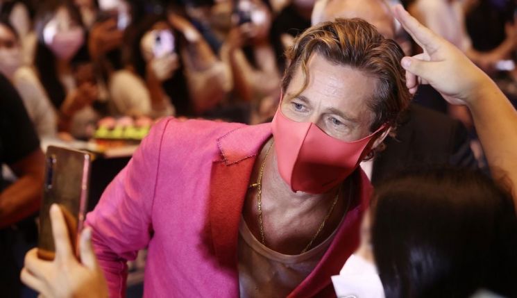 할리우드 배우 브래드 피트가 지난해 7월말 영화 '불릿 트레인' 시사회에서 팬들과 촬영을 하고 있다. 브래드 피트는 여성 패션의 전형적인 컬러인 핑크색 옷을 입고 등장, 눈길을 끌었다. [이미지출처=연합뉴스]