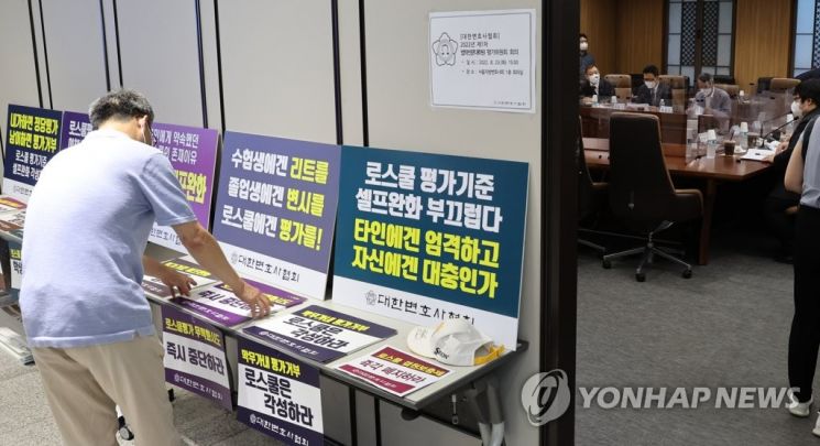 지난해 8월 23일 서울지방변호사회관에서 법학전문대학원(로스쿨) 평가위원회 회의를 하고 있다. 회의장 앞에 평가기준 개정안과 관련한 대한변협의 항의 손팻말이 놓여 있다.