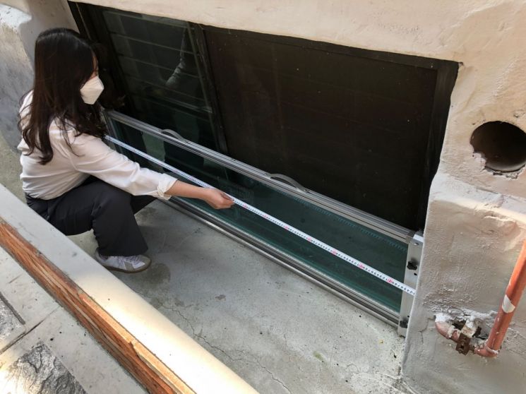 돌봄공무원이 반지하주택에 설치된 물막이판을 점검하고 있는 모습