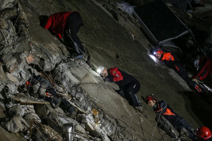 6일(현지시간) 튀르키예 구조대원들이 실종자를 찾기 위해 건물 잔해에 귀를 대고 있다. [사진출처=EPA연합뉴스]