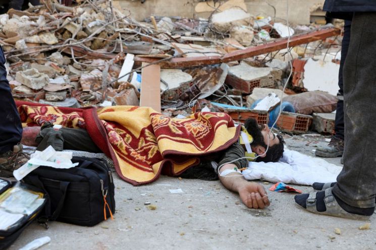 강진 발생 사흘째인 8일(현지시간) 튀르키예 남동부 하타이에서 한 주민이 건물 잔해에서 구조된 뒤 수액을 맞고 있다. [이미지출처=연합뉴스]