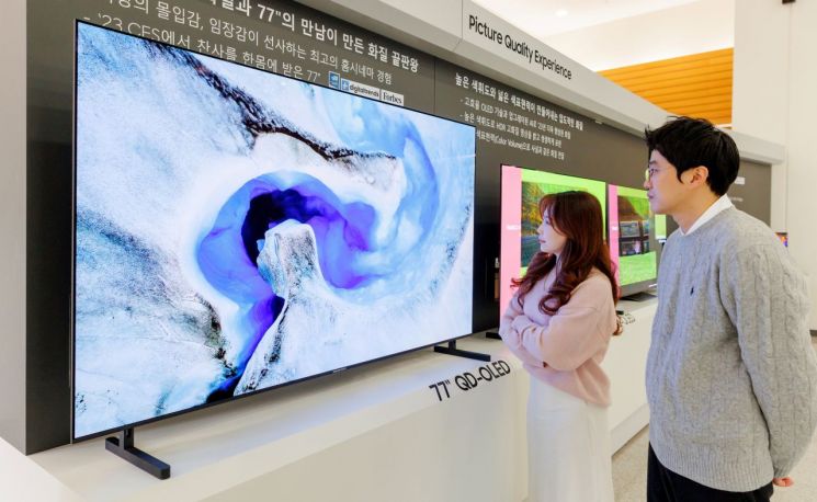 삼성디스플레이 직원들이 초대형 77형 TV용 QD-OLED 제품을 관람하고 있다.