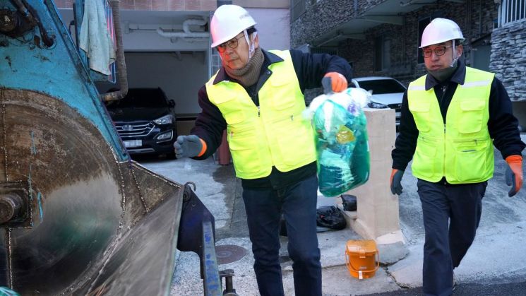 홍태용 경남 김해시장(왼쪽)이 거리를 돌며 주민이 내놓은 쓰레기 종량제 봉투를 청소차에 싣고 있다. [사진제공=김해시청]