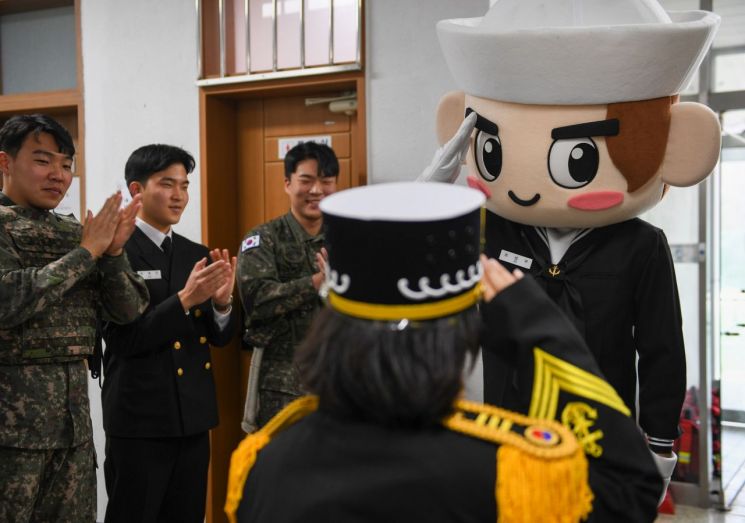 해군 캐릭터 ‘이나비’가 해군 제복을 입은 아이와 경례를 주고받고 있다. [사진제공=해군 진해기지사령부]