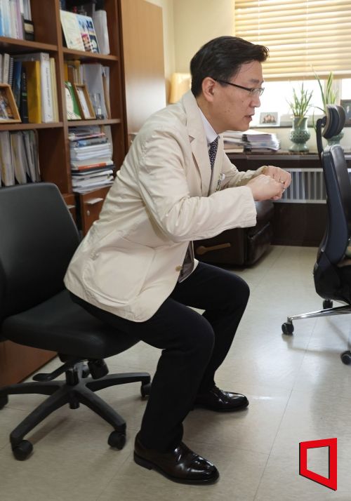 양동원 대한치매학회 이사장이 서울 카톨릭 의대 연구실에서 노년기 근력운동의 중요성을 이야기하며 의자에 의지한 스쿼트 시범을 보이고 있다. 사진=허영한 기자 younghan@