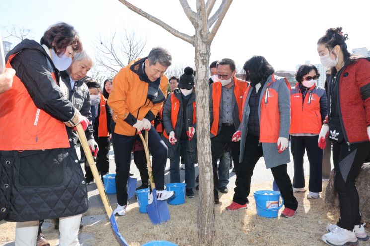 이강덕 포항시장이 철길숲 나무에 직접 고형비료를 주고 있다.