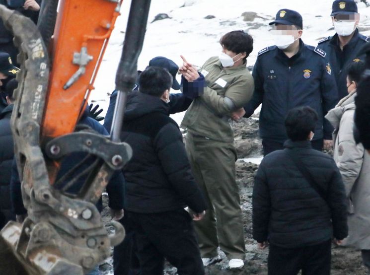택시 기사와 동거녀를 살해한 혐의로 구속된 이기영이 경기도 파주 공릉천변에서 검찰 관계자들에게 시신을 매장했다고 진술한 부근을 손으로 가리키고 있다. [이미지출처=연합뉴스]