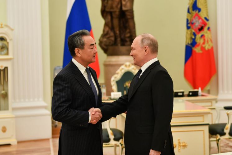 사진은 블라디미르 푸틴 러시아 대통령(오른쪽)이 22일(현지시간) 수도 모스크바 크렘린궁에서 왕이 중국공산당 중앙정치국 위원과 악수하고 있는 모습. [이미지출처=연합뉴스]