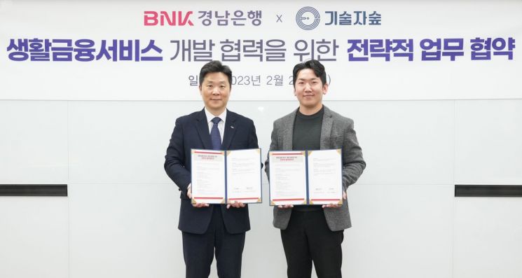 BNK경남은행 김진한 상무(사진 왼쪽)와 기술자숲 공태영 대표가 ‘생활금융서비스 개발 협력을 위한 전략적 업무 협약’을 체결하고 있다.