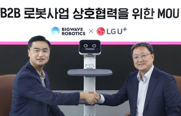 임장혁 LG유플러스 기업신사업그룹장(오른쪽)과 김민교 빅웨이브로보틱스 대표(왼쪽)가 업무협약식에서 기념촬영을 하고 있다.