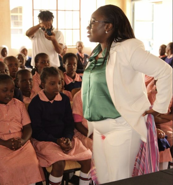 케냐의 글로리아 오워바 상원의원이 지난달 14일 붉은 자국이 묻은 하얀색 바지 정장을 입고 나이로비 학교를 찾아 무료 생리대를 나눠주고 있다. 사진 글로리아 오워바 트위터 캡처