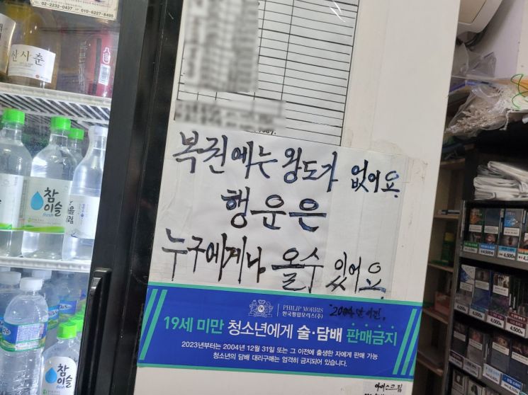 2등 당첨자 103명이 나온 복권판매소에 사장 부부가 붙혀놓은 글귀. 사진=한승곤 기자