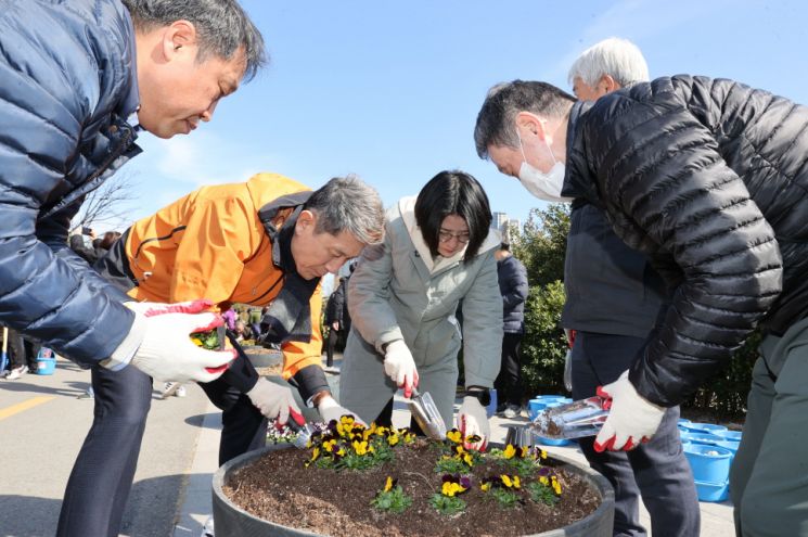 지난달 22일 이강덕 포항시장(왼쪽 두번째)이 철길숲 산책로에서 봄꽃을 원형 화분에 식재하고 있다.