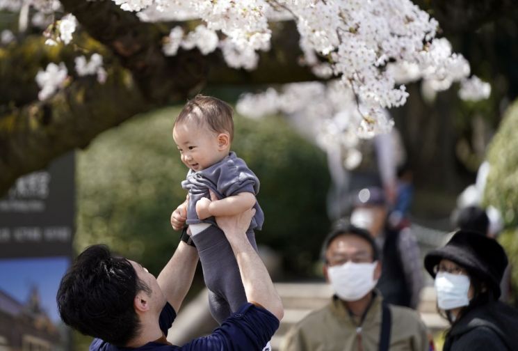일본 도쿄에서 한 아버지가 아기를 들어 올리고 있다. 사진은 기사의 특정내용과 관련없음. [사진출처=EPA 연합뉴스]