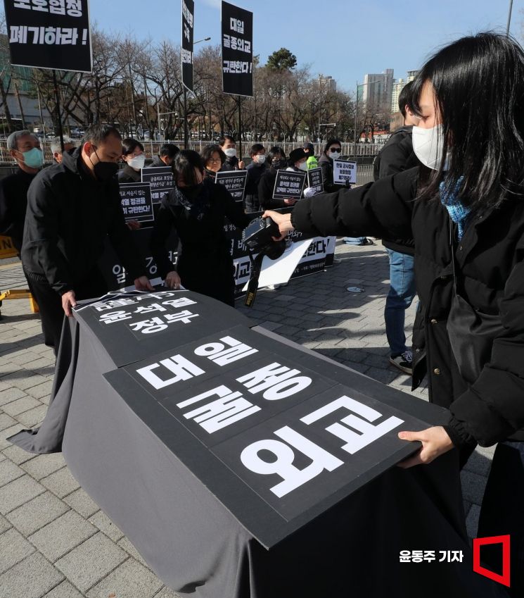 평통사 회원들이 16일 서울 용산구 대통령집무실 앞에서 '일제 강점과 전범기업 배상 책임에 면죄부 주는 윤석열 정권의 굴종외교를 규탄'하는 긴급 기자회견에서 윤 정권의 사망을 상징하는 관을 설치하고 있다. 사진=윤동주 기자 doso7@