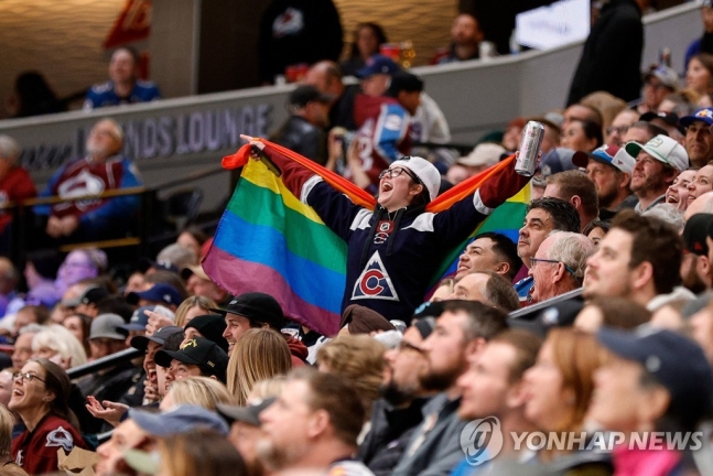 NHL 경기 중 한 팬이 성소수자를 상징하는 무지개 깃발을 펼쳐보이고 있다 [이미지출처=연합뉴스]